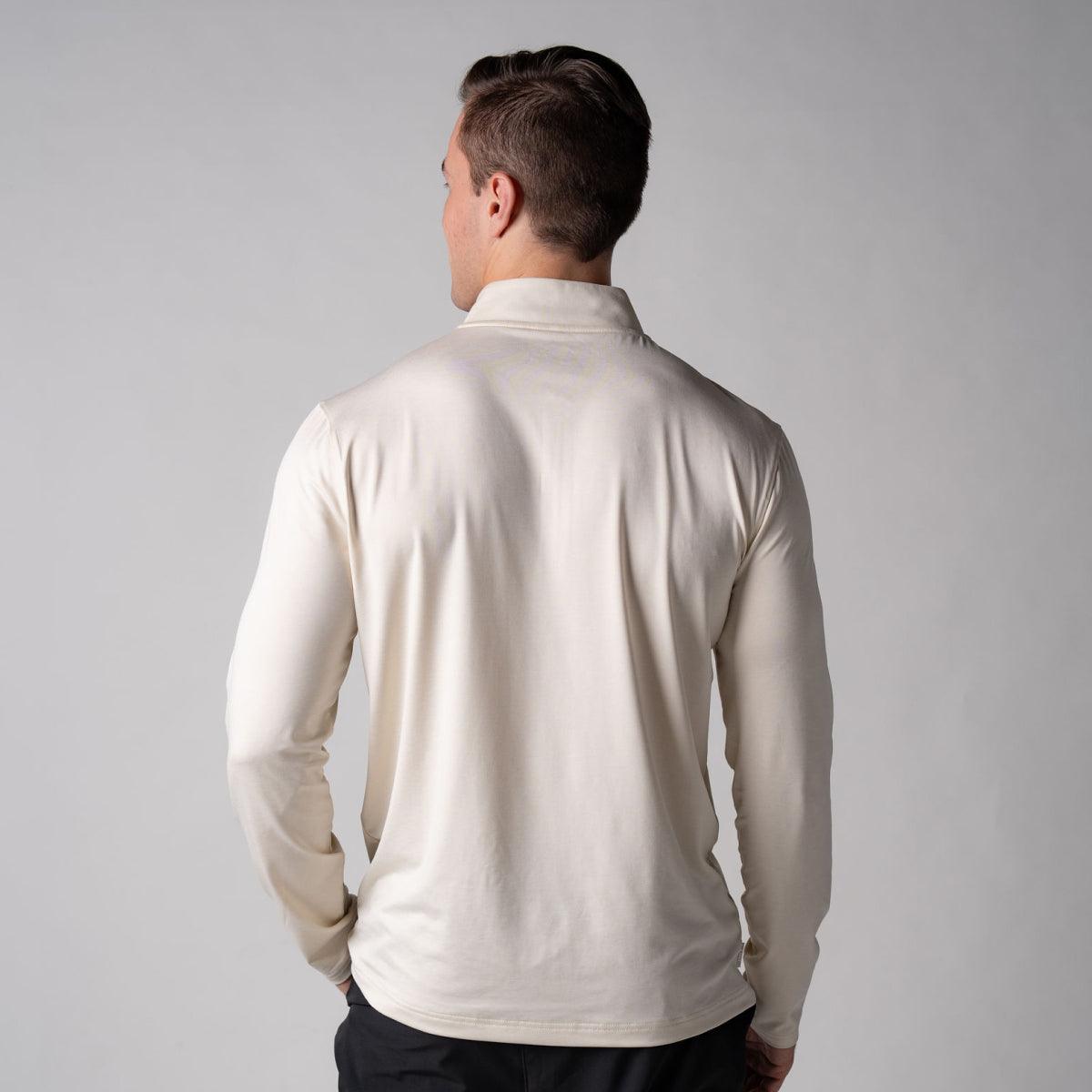 Mann von hinten in langärmligem, cremefarbenem Poloshirt vor grauem Hintergrund.